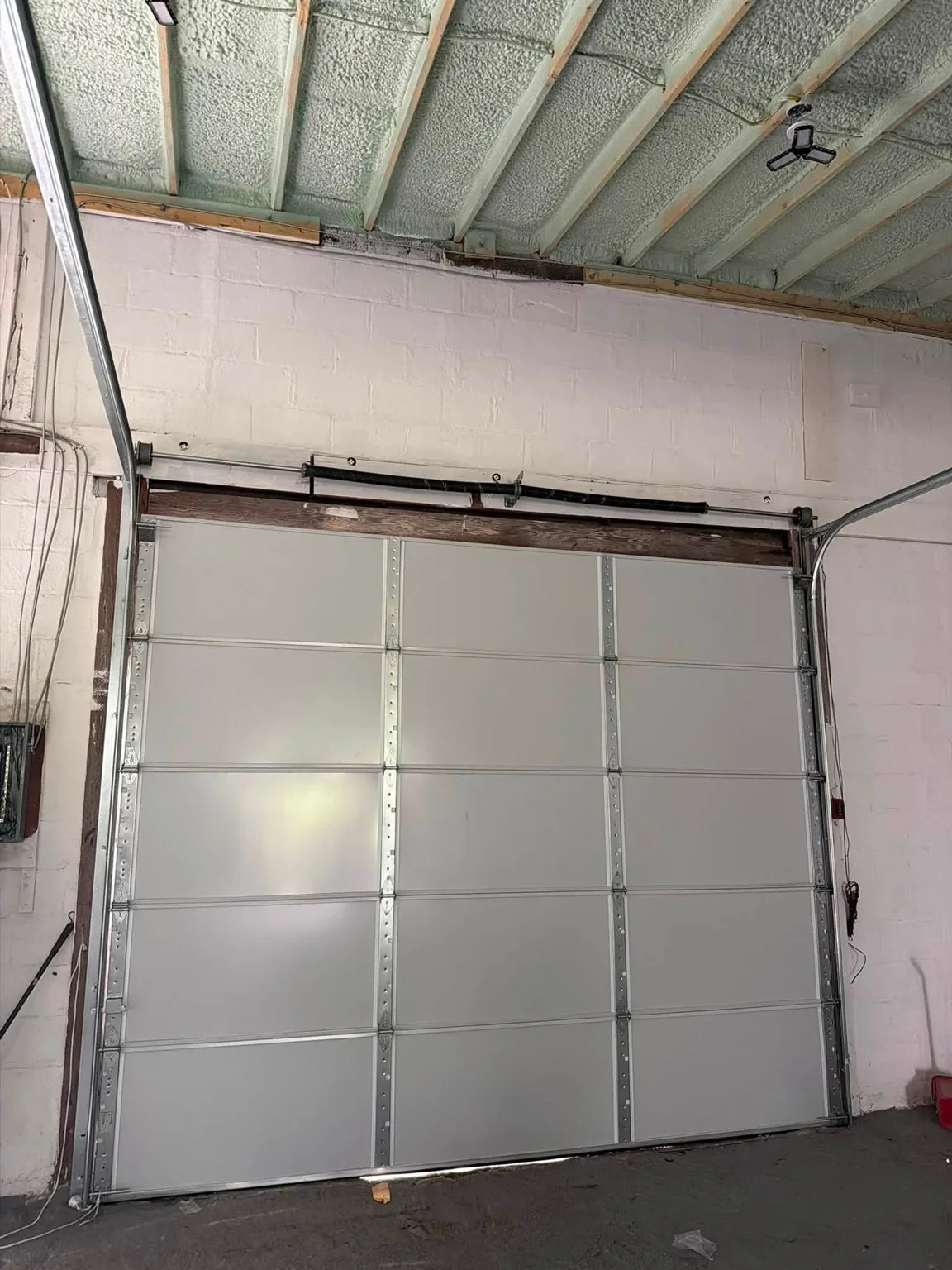 Interior view of the replacement sectional garage door and its track hardware